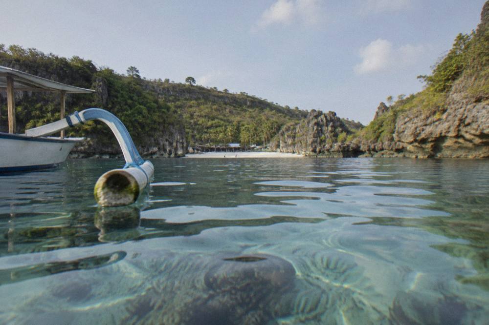 Calm, clear water of a sheltered bay with a sandy bottom and coral heads
