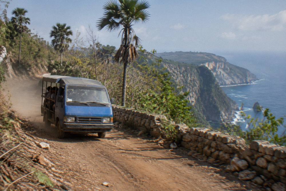 Coastal road winding along cliffs above the sea on Nusa Penida