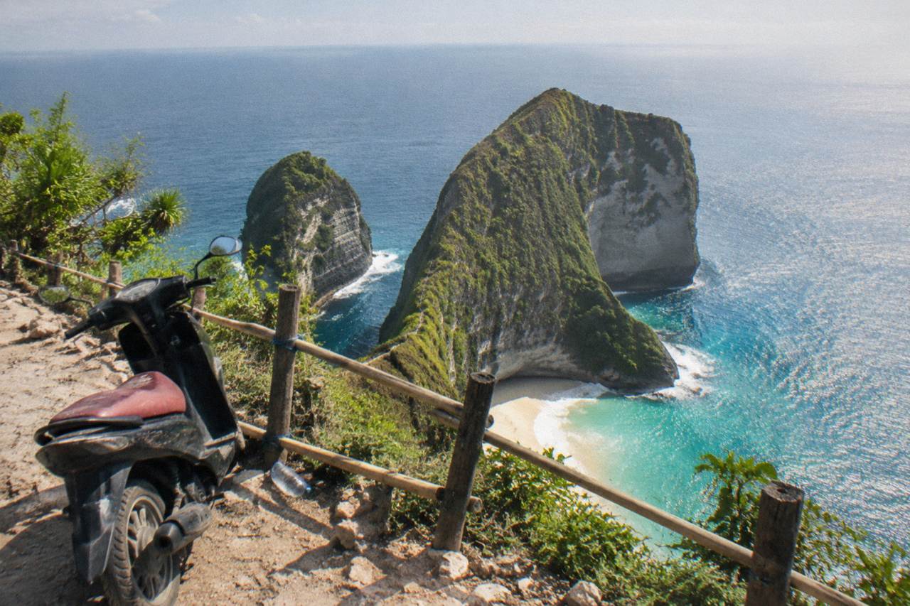 Viewpoint over a limestone cliff and turquoise bay on Nusa Penida at midday