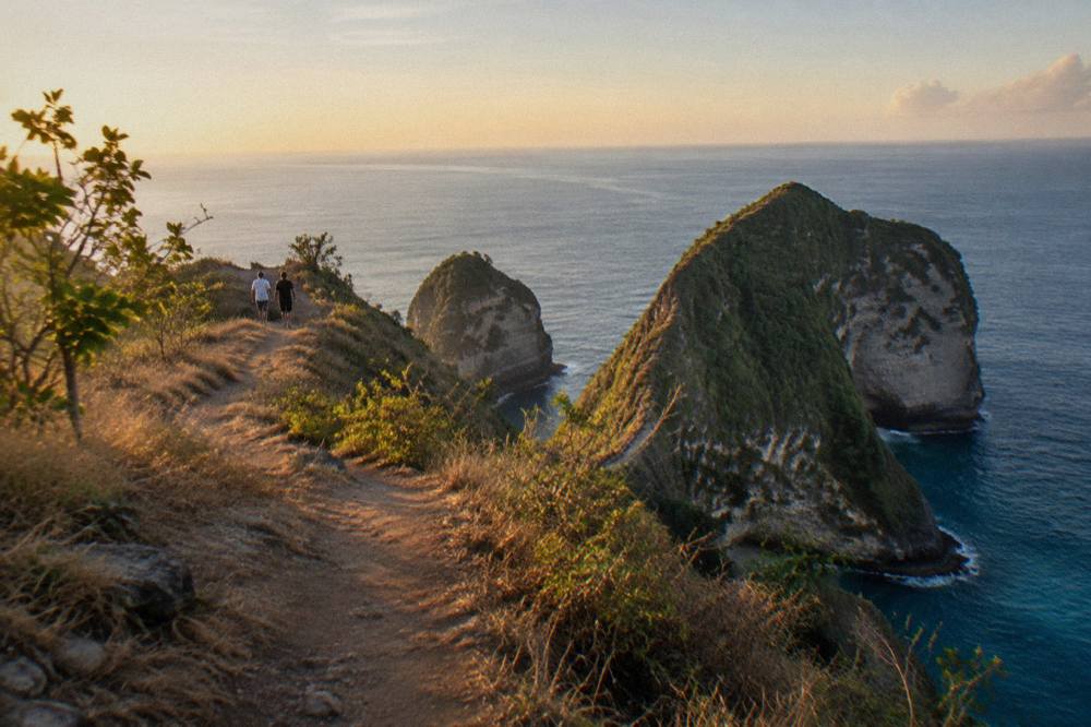 A coastal viewpoint path along a green cliff top above calm blue sea