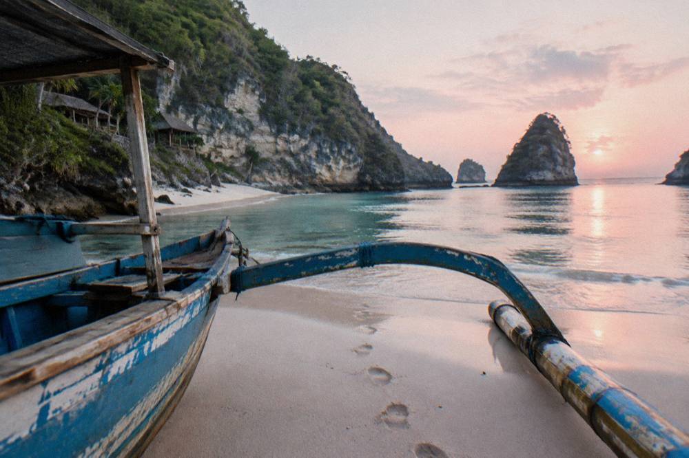 A quiet beach cove with white sand and clear shallow water in early morning light