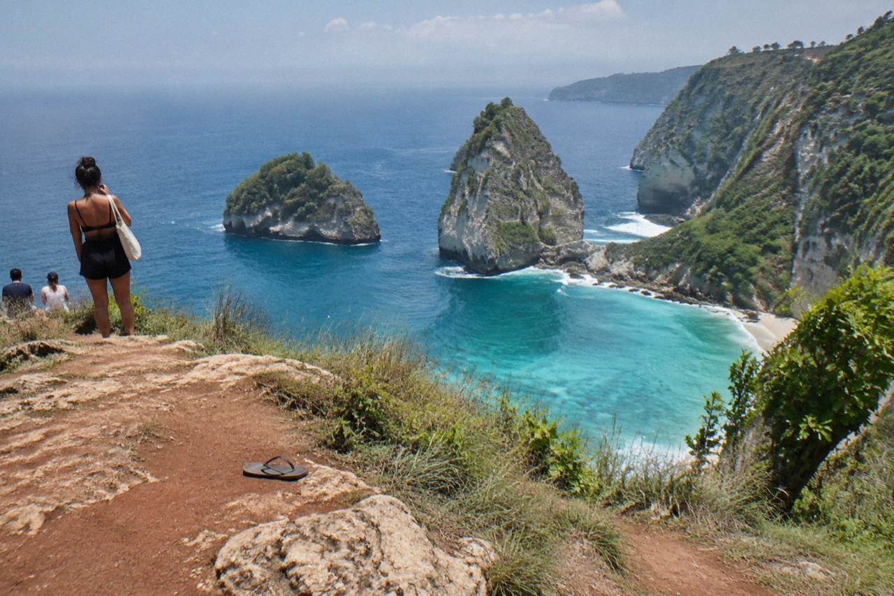 Turquoise water and limestone cliffs along the Nusa Penida coastline at midday