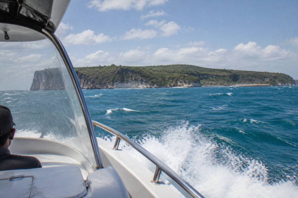A fast boat crossing open water between Bali and Nusa Penida with spray at the bow