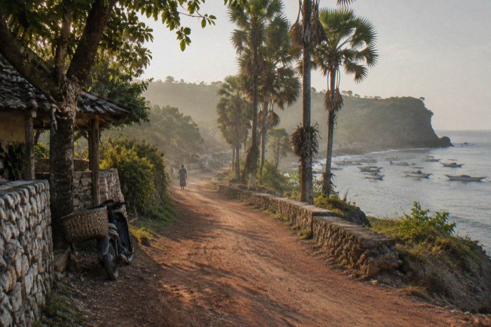 A coastal road winding along green cliffs above the sea on Nusa Penida