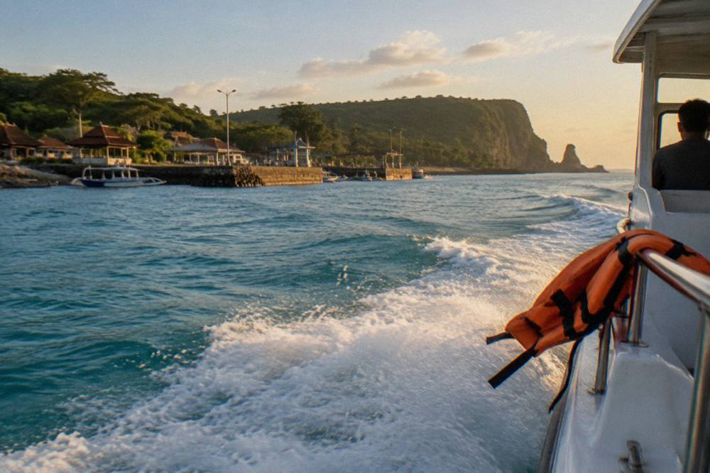 A fast boat cutting across open water between Bali and Nusa Penida