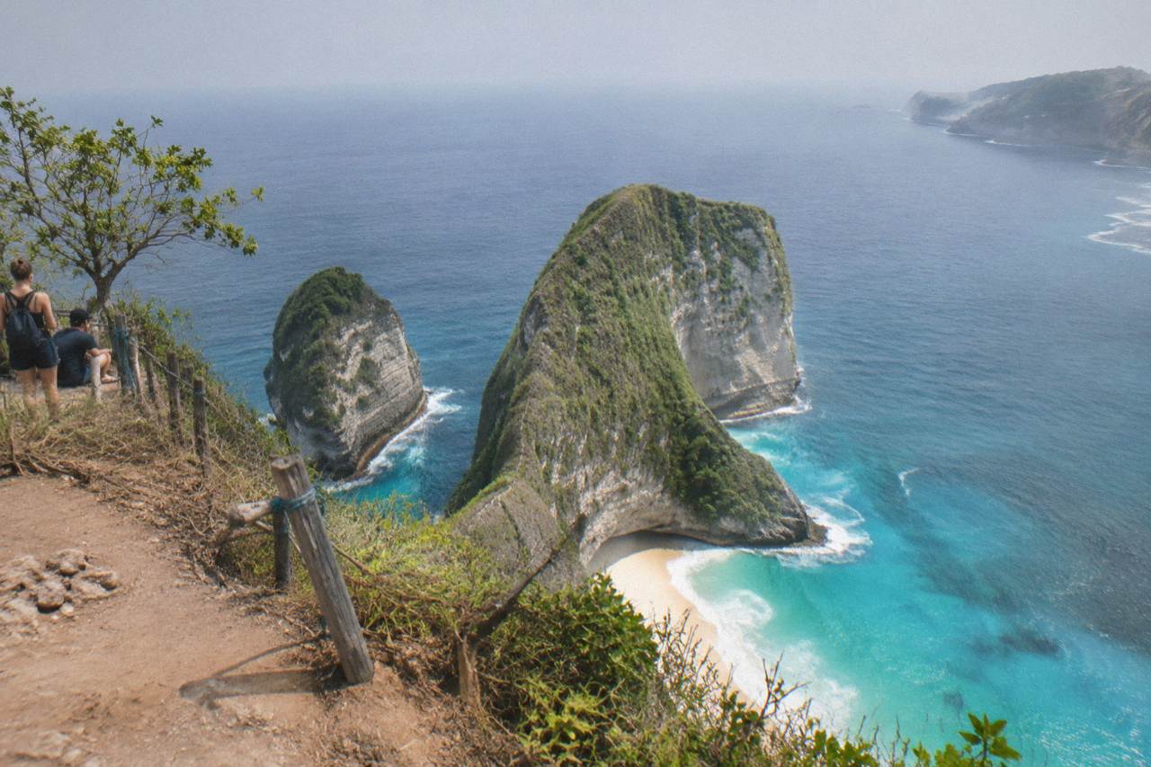 The T-Rex shaped cliff of Kelingking Beach on Nusa Penida seen from the viewpoint above white sand and turquoise water