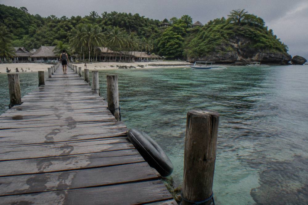 Wooden pontoon walkway over clear water at a Nusa Penida snorkelling stop