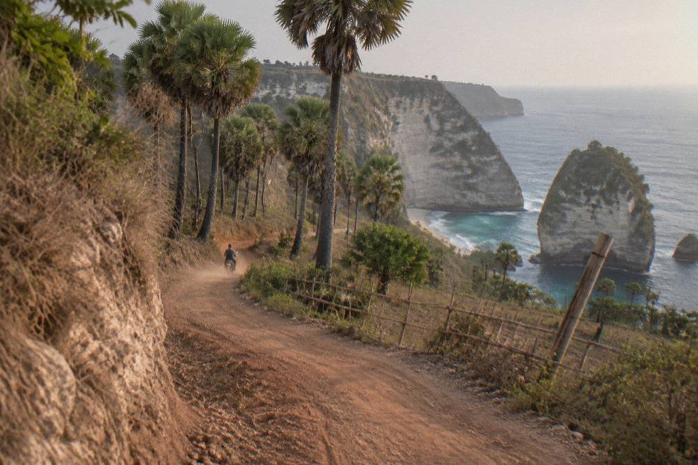 Coastal cliff road winding above the sea on the way to a Nusa Penida viewpoint