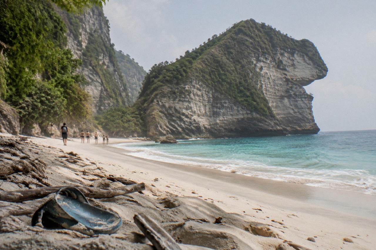 Turquoise water below a tall limestone cliff headland on a calm day
