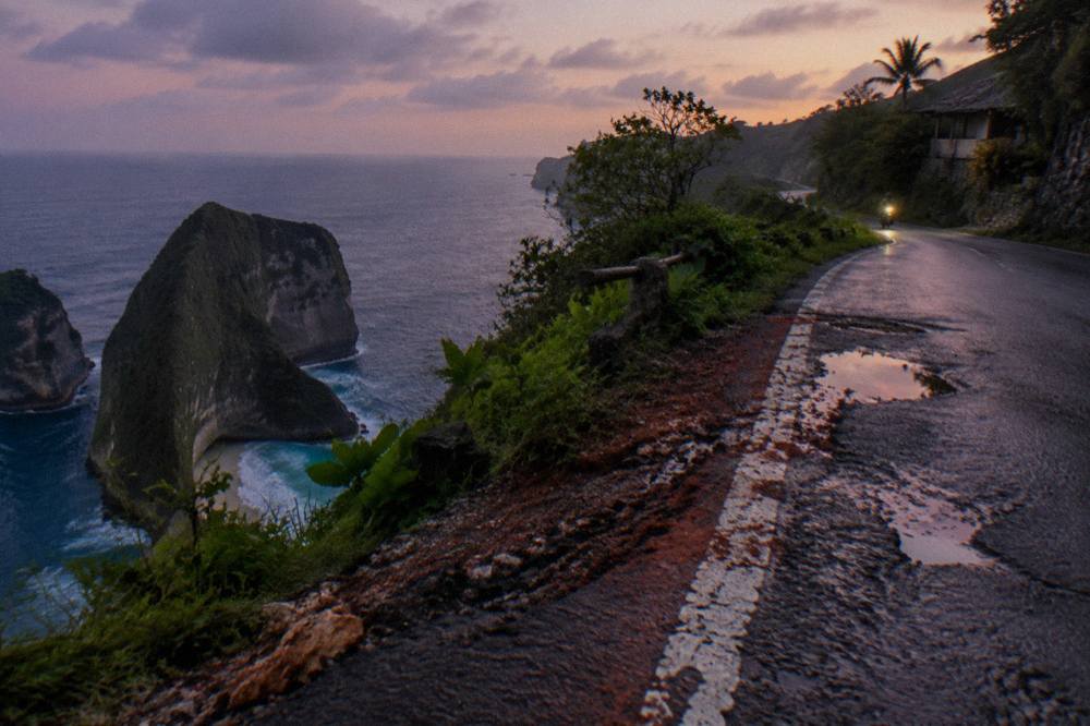 A narrow coastal road on Nusa Penida winding along clifftops above the sea