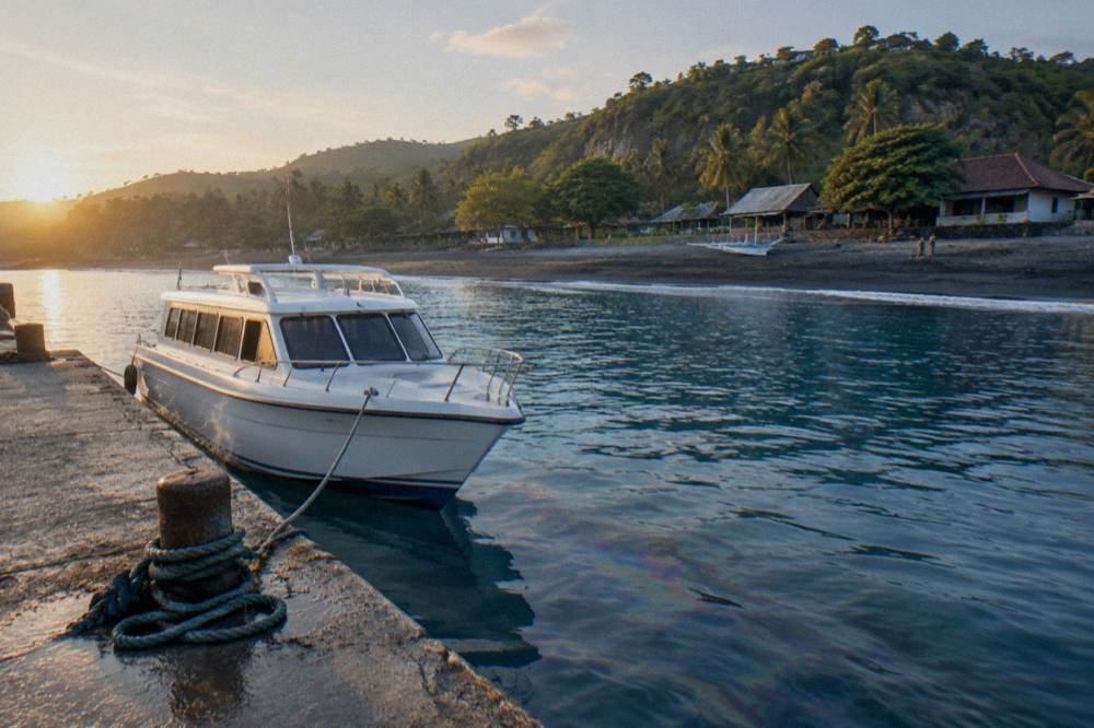 A fast boat moored at a harbour jetty in early morning light