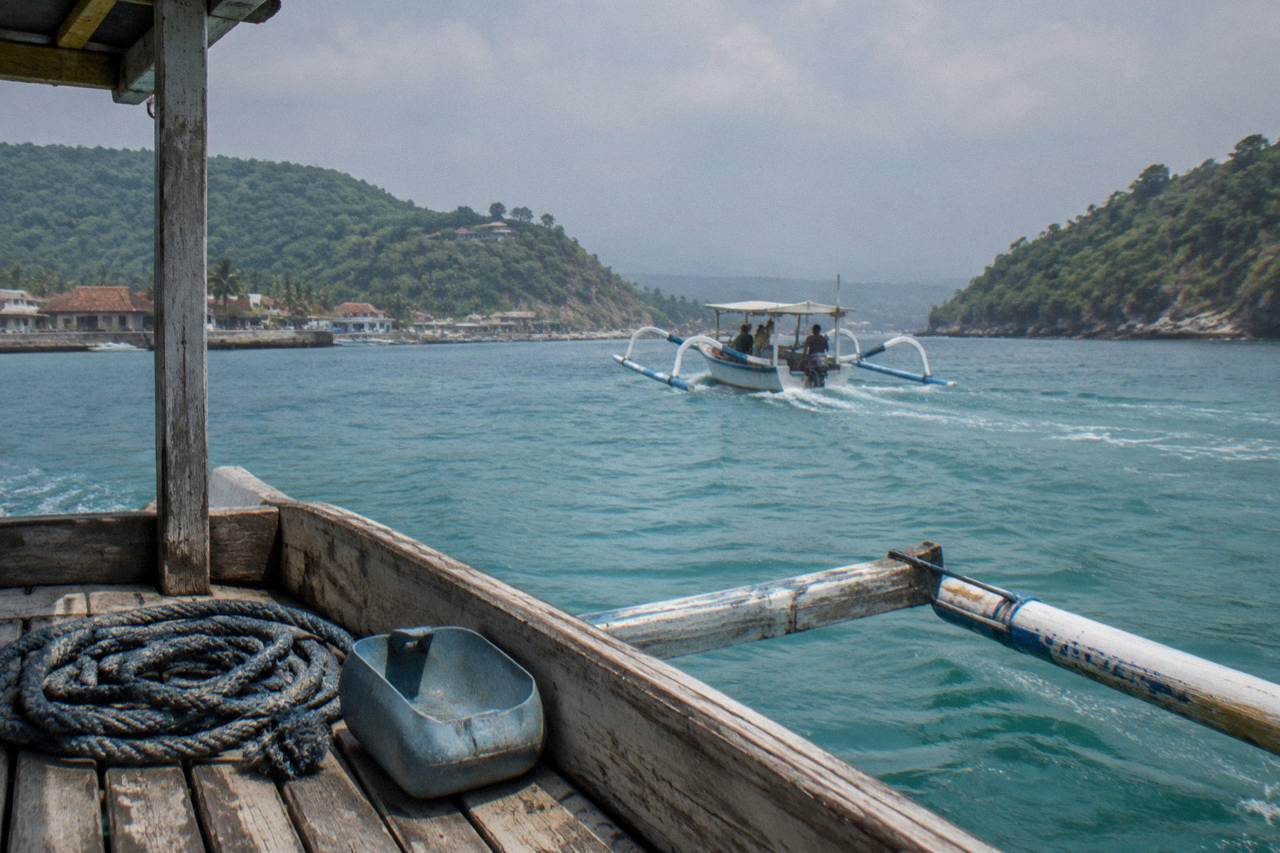 Turquoise channel between two green islands with a small boat crossing