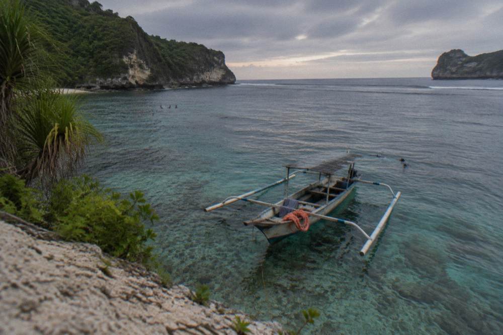 A snorkel boat anchored over clear shallow water above a reef
