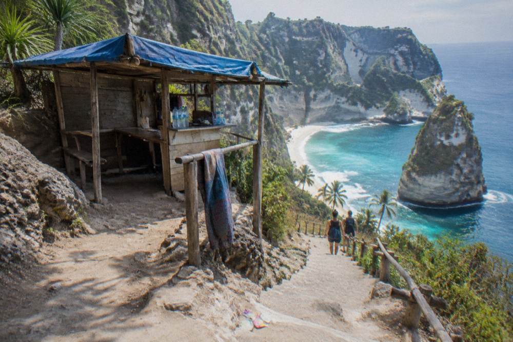 A cliffside ticket booth and path above a tropical beach