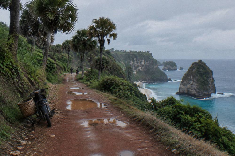 A coastal road winding along green cliffs above the sea