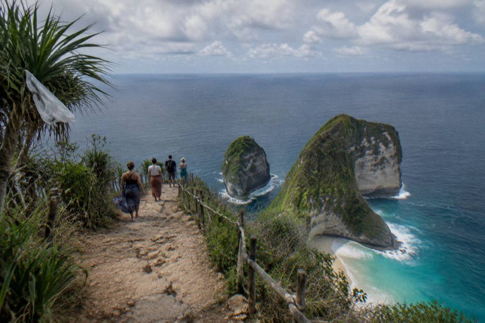 Tour group at Kelingking viewpoint with the iconic T-Rex cliff formation in the background