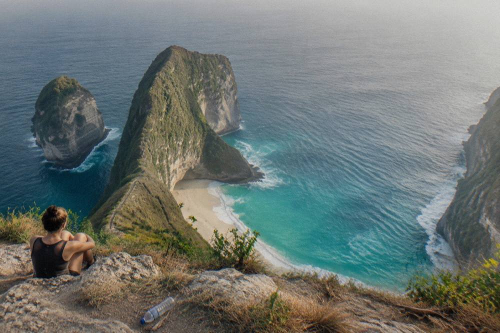 Turquoise sea and white sand cove seen from a high limestone cliff top