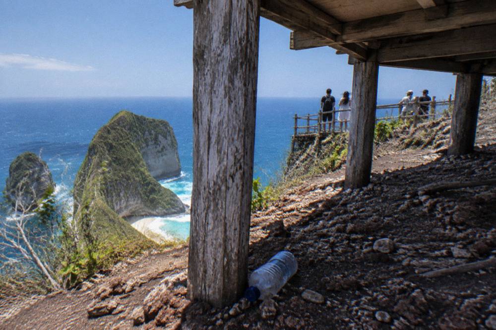 Wooden viewpoint platform above a cliff with visitors at a fence line
