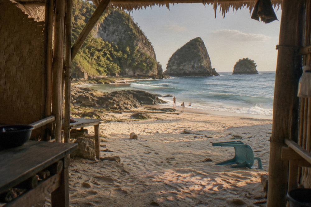 White sand cove at Atuh Beach framed by green cliffs and small offshore islands