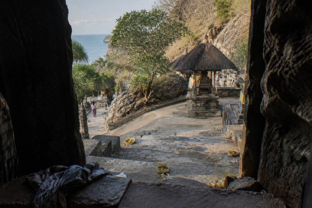 The entrance steps to a cave temple on Nusa Penida with offerings beside the doorway