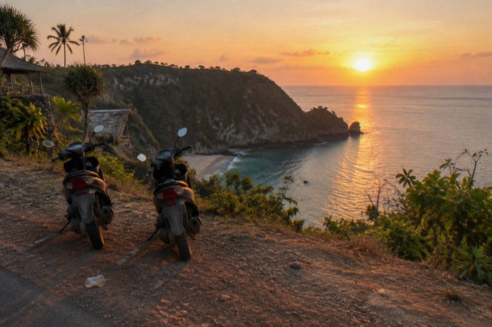 Sunset light over calm sea and dark cliffs on the west coast of Nusa Penida