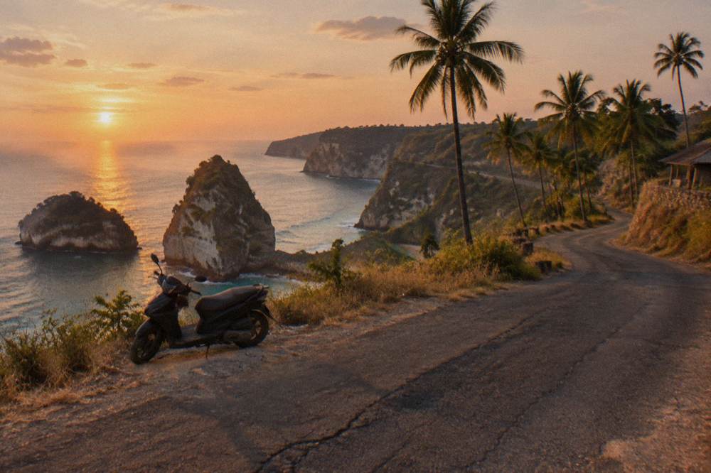A coastal road winding along the Nusa Penida shoreline between viewpoints