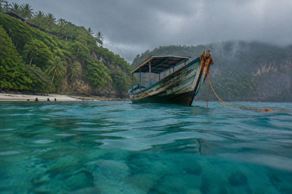 A snorkel boat over clear turquoise water near a Nusa Penida bay
