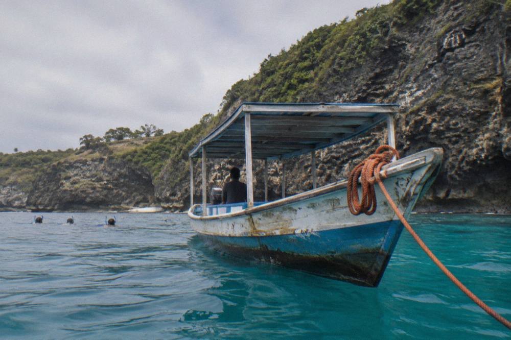 Snorkel boat anchored above turquoise water at a rocky south coast bay