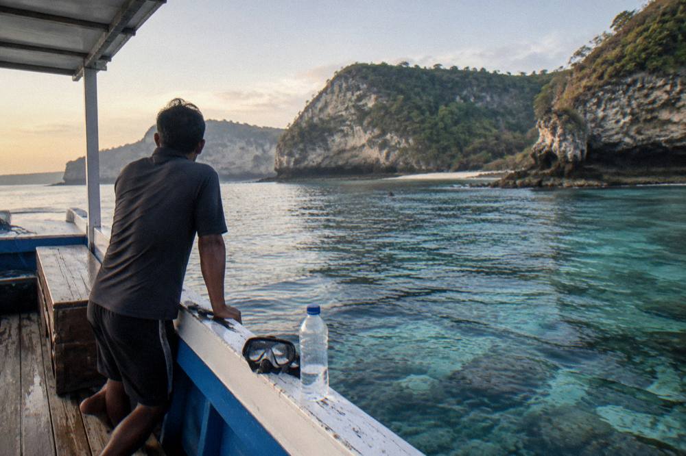 Small snorkeling boat and guide waiting in a calm bay