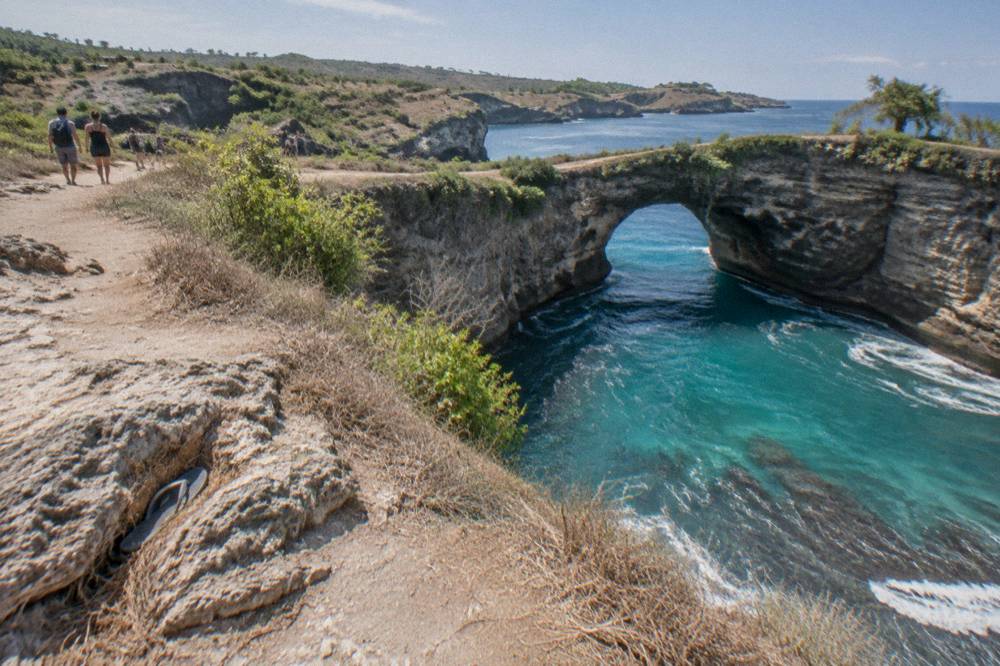 A limestone arch and turquoise cove on the west coast of Nusa Penida