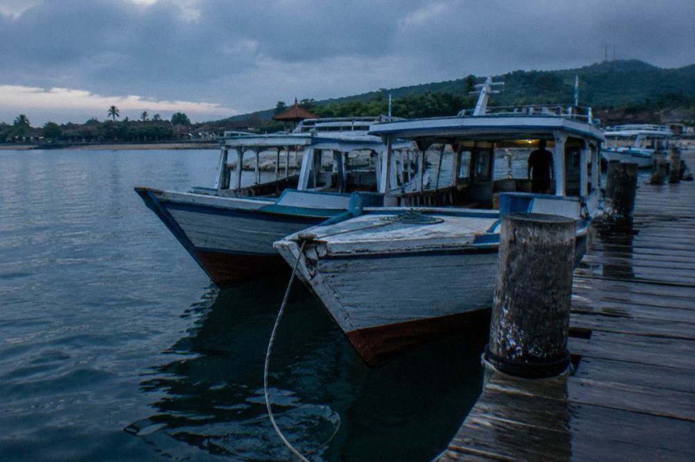 Fast boats moored at a wooden jetty in Sanur harbour at first light