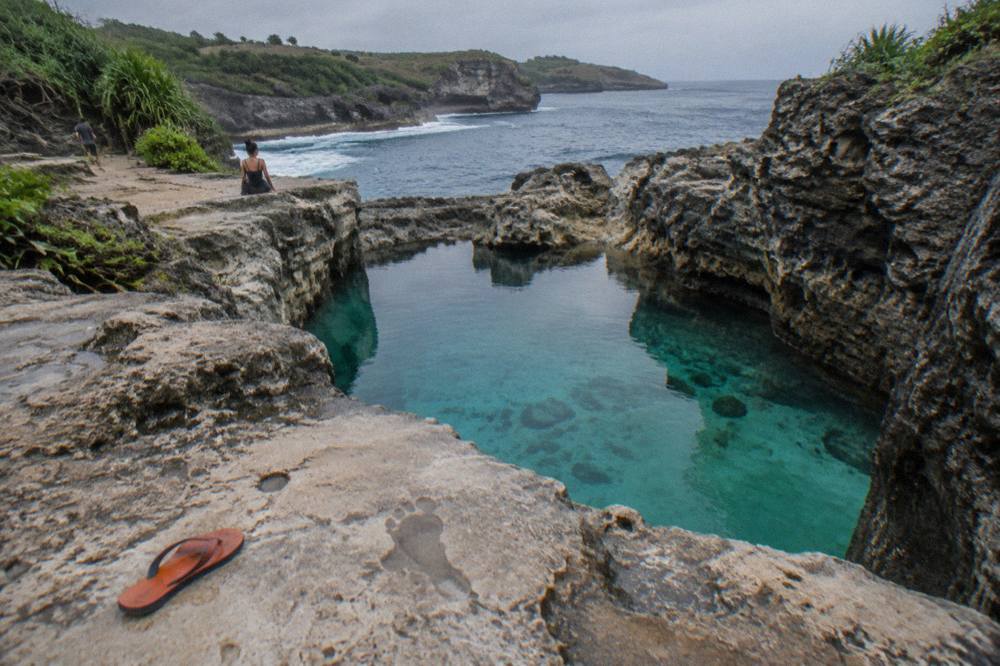 Turquoise water filling the natural rock pool at Angel's Billabong at low tide