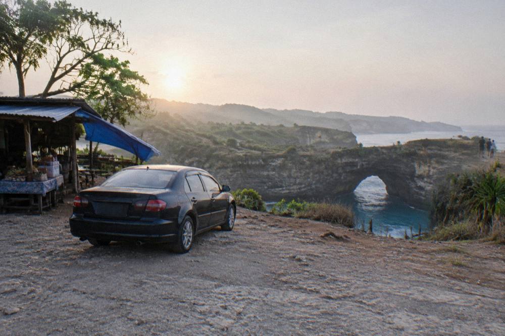 A private car parked at a viewpoint overlook on the Nusa Penida west coast