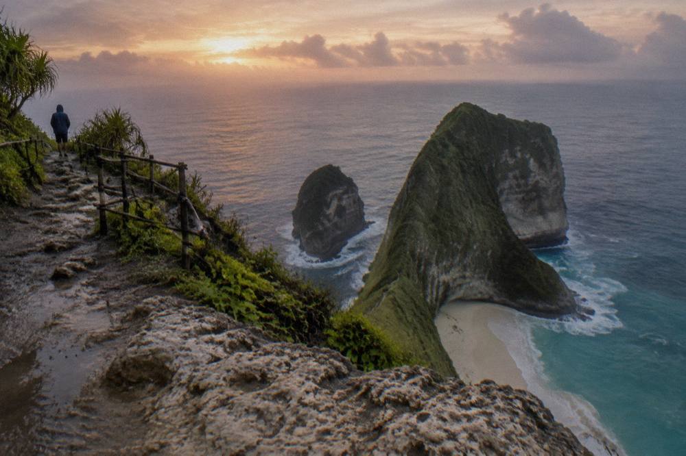 Sunrise light over the T-Rex cliff at Kelingking Beach with an empty viewing platform